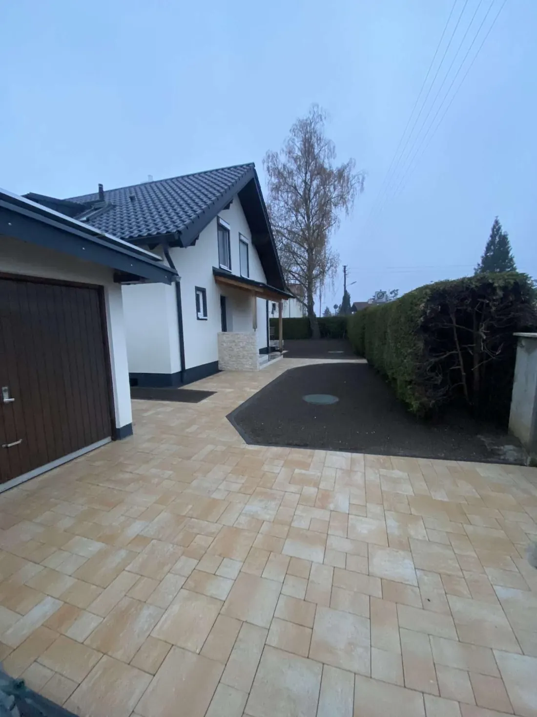 Ein Haus mit Garage und gepflasterter Auffahrt
